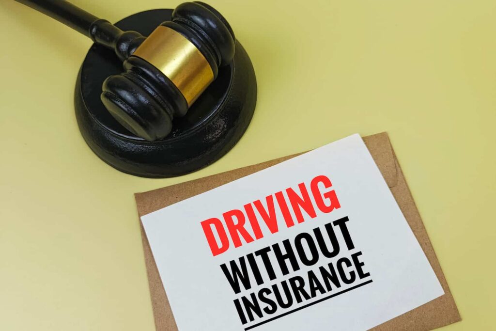 Driving without insurance legal concept with judge gavel and warning sign about uninsured driver consequences