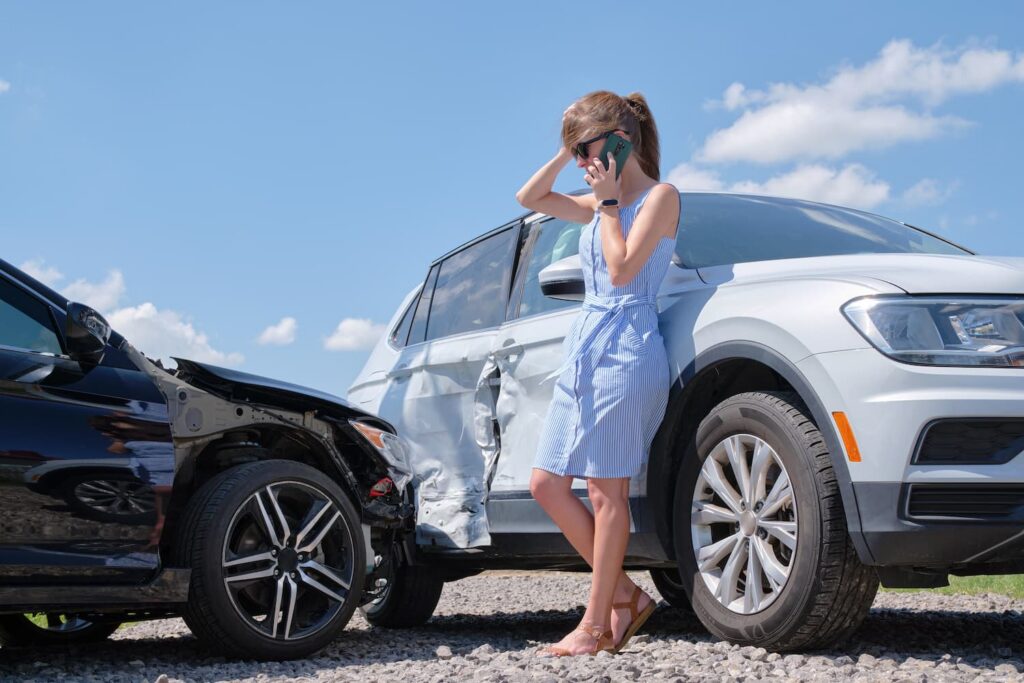 Parker County Car Accident Scene – What to Do After a Crash Woman calling after car accident on rural road with damaged vehicles in Parker County